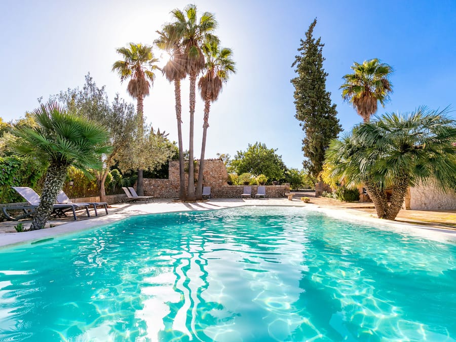 Una piscina al aire libre de temporada, sombrillas, tumbonas