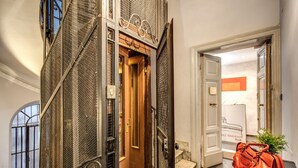 A staircase with ornate metal railings and a wooden door leading to a room. - La Residenza dell'Angelo (Rome)