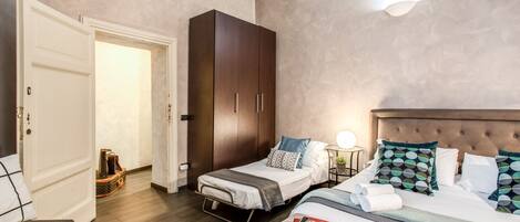 Un dormitorio con cama, mesita de noche y armario.