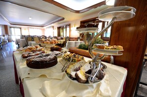 A buffet table with various desserts and pastries.