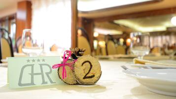 A table setting with a name card, a number card, and a glass of water.