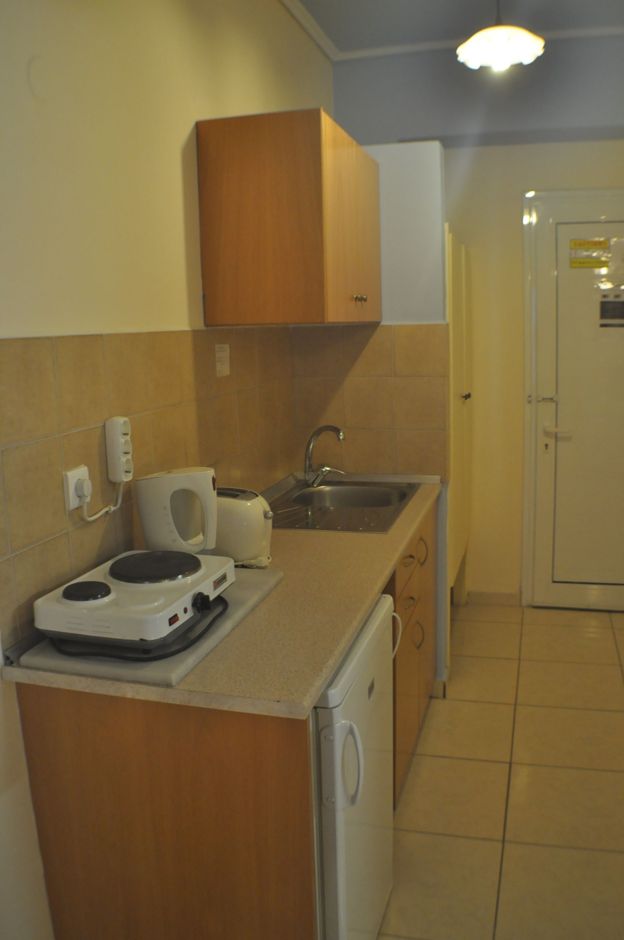 A compact kitchen with a microwave, toaster, and sink.