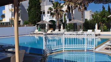 Una piscina al aire libre, tumbonas