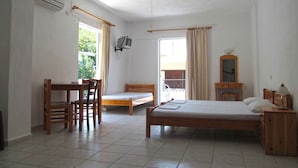 A room with a bed, a desk, a chair, a TV, and a ceiling fan. - Pagona Hotel (Istiaia-Aidipsos)