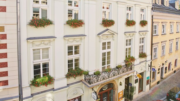 A multi-story building with multiple windows and balconies, some with flower boxes. - Unikat Guest Rooms (Self-check in) (Kraków)