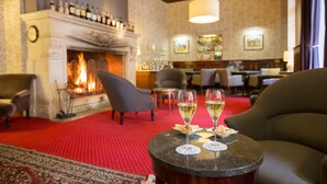 Een hotellobby met een open haard, zithoek en bar.