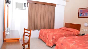 Habitación de hotel con dos camas, un escritorio, una silla, una ventana con cortinas y un cuadro en la pared.
