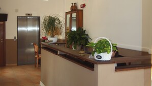 Uma cozinha com ilha integrada, geladeira e plantas em vasos.