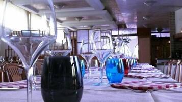 A dining table with multiple wine glasses and a black vase.