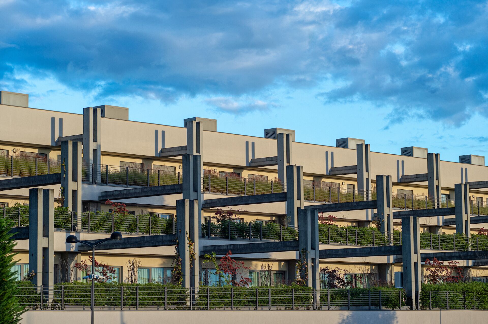 A multi-story building with a modern architectural design, featuring balconies and a flat roof.