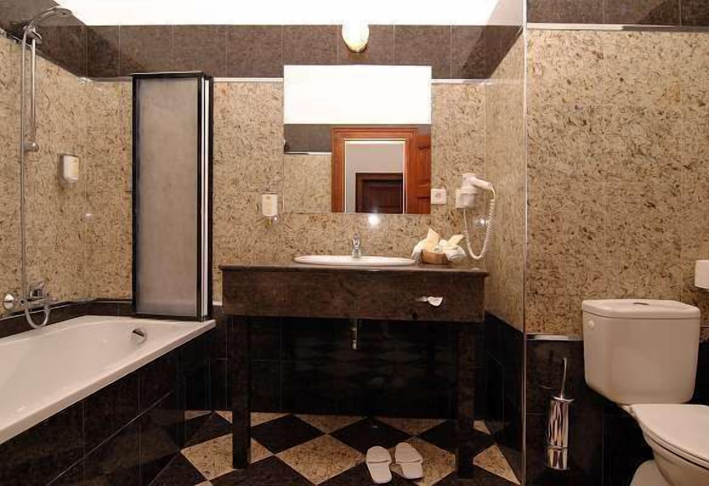 A modern bathroom with a bathtub, sink, and toilet.