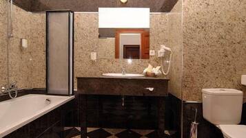 A modern bathroom with a bathtub, sink, and toilet.