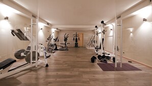 A modern gym with cardio machines, free weights, and a mirror wall. - Hotel La Torretta (Vermiglio)