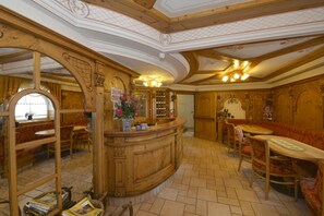 A traditional inn with wooden interiors, a bar area, and seating for guests. - Hotel La Torretta (Vermiglio)