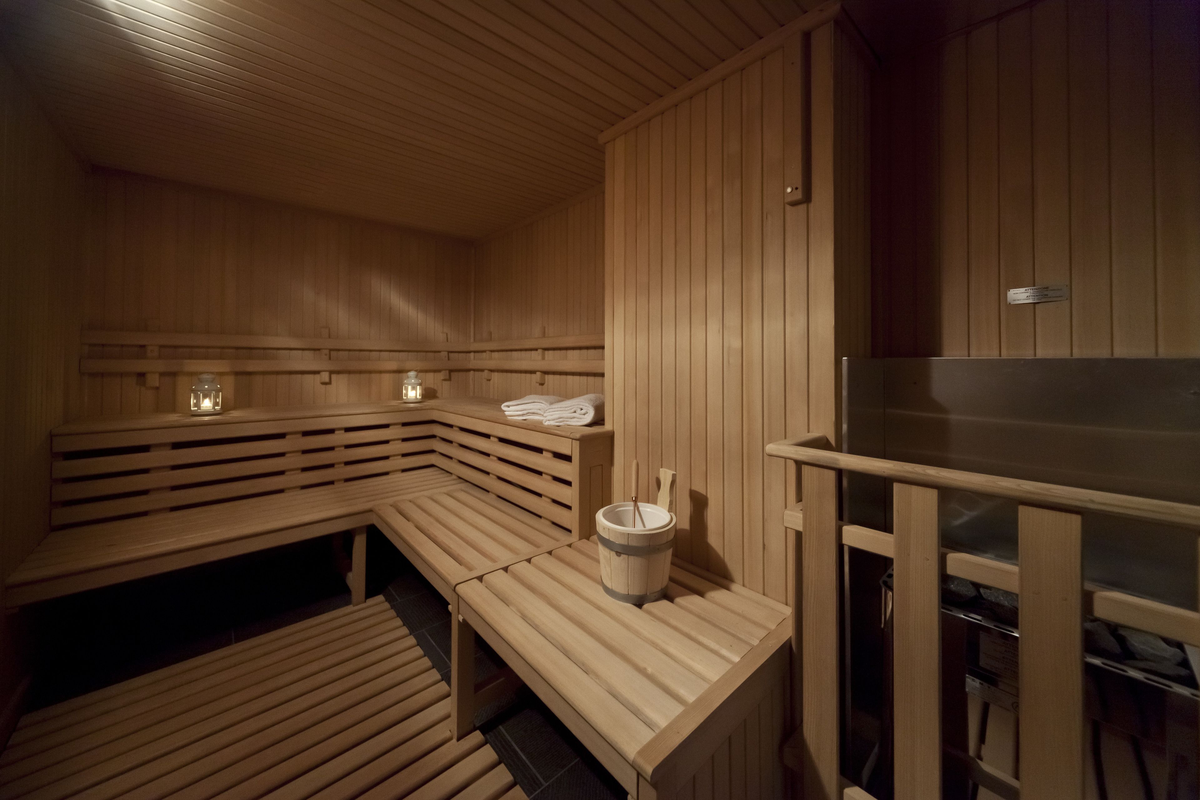 Un sauna en bois avec des bancs et un seau.