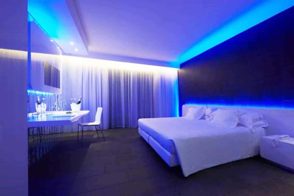 Une chambre d’hôtel moderne dotée d’un grand lit, d’un bureau avec une chaise et d’un espace salle de bain.