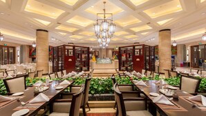 A spacious dining area with long tables, chairs, and a central chandelier. - Yourworld International Conference Center (Jinhua)
