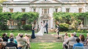 A wedding ceremony in front of a large, classical building with steps leading up to the entrance.