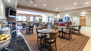 A hotel lobby with multiple seating areas, a coffee station, and a kitchen in the background. - Quality Inn & Suites Bel Air I-95 Exit 77A (Edgewood)