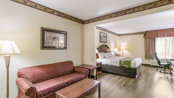 A hotel room with a sofa, a bed, a desk, and a chair.