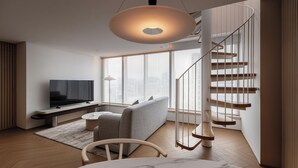 Un salon moderne avec un t éléviseur, un canapé et une table à manger.