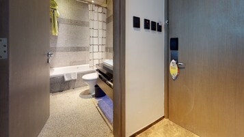 A modern bathroom with a bathtub, toilet, and sink.