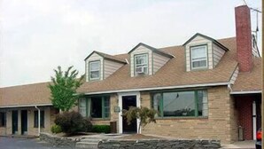 A two-story building with a brick facade, large windows, and a sloped roof. - Driftwood Inn (Chestertown)