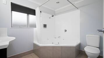 Ein modernes Badezimmer mit Badewanne, Toilette und Waschbecken.