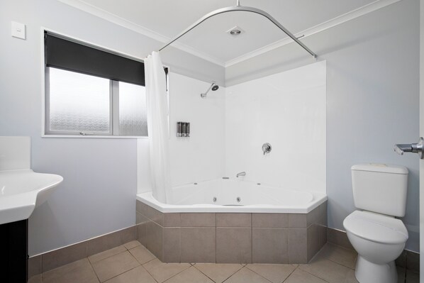 Une salle de bain moderne avec une baignoire, des toilettes et un lavabo.