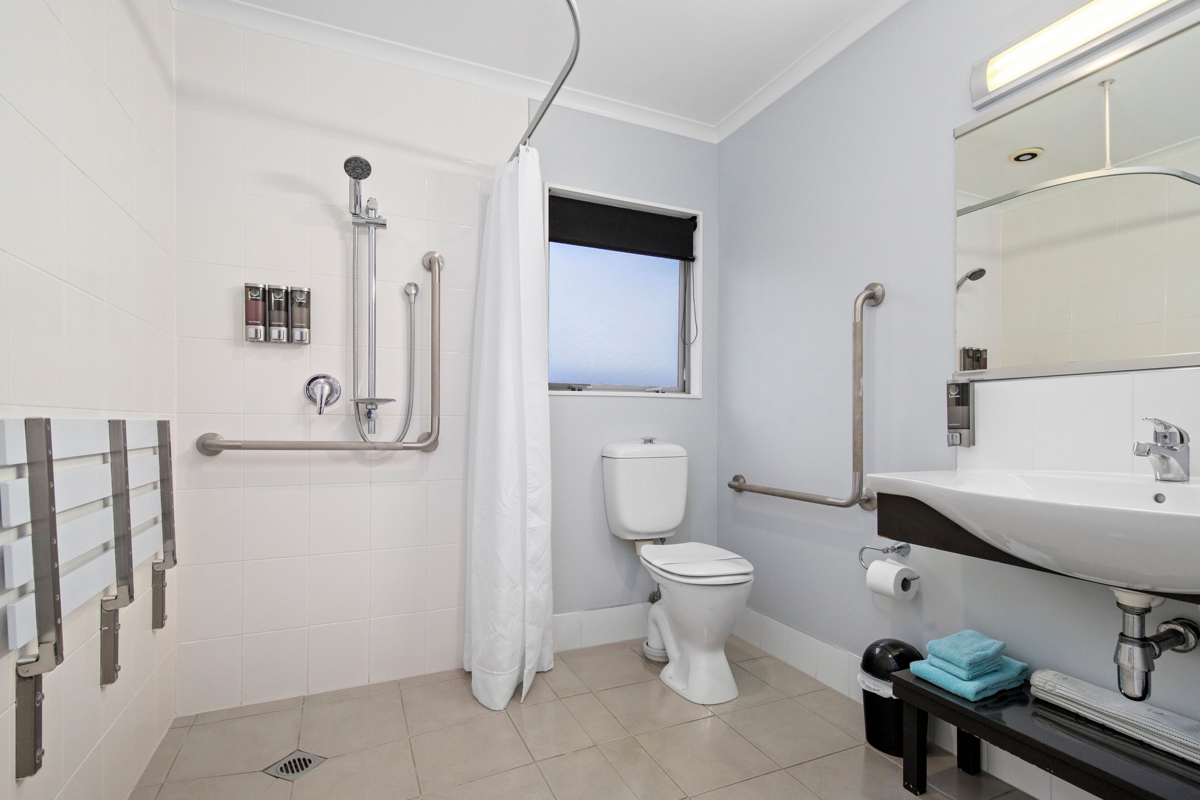 Et moderne badeværelse med bruser, toilet og vask.