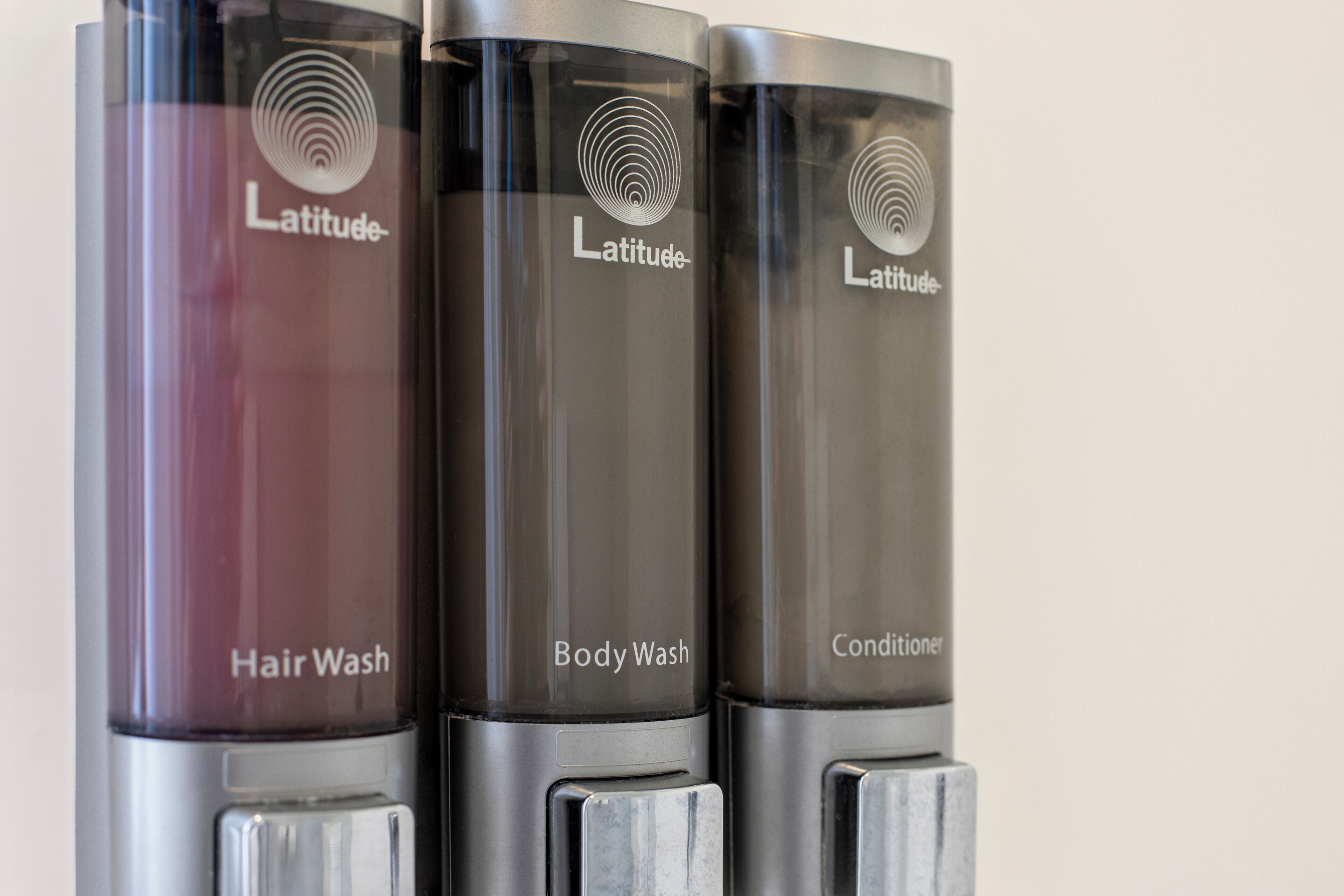 Tres botellas de champú, gel de ducha y acondicionador Latitude.