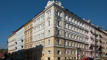 Un edificio histórico con varios pisos, amplias ventanas y detalles arquitectónicos ornamentales.