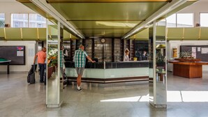 A lobby with a reception desk, glass partitions, and a clock on the wall. -  Hotel Medena Budget (Seget)
