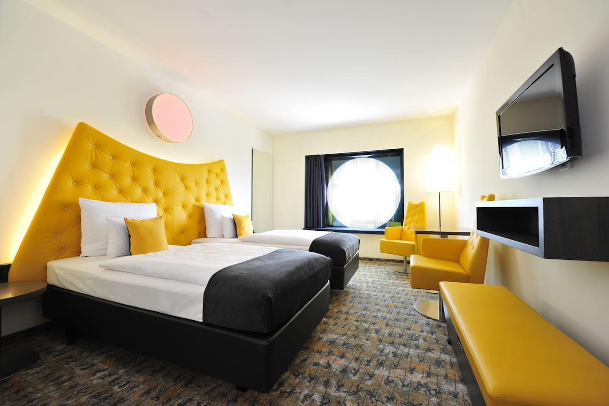 Una habitación de hotel con una cama grande, televisión de pantalla plana, un sofá y un escritorio.