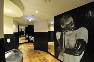 Ein modernes Badezimmer mit großem Spiegel, Waschbecken und Fliesenboden.