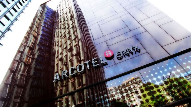 A tall building with the sign "ARCOTEL" and "ANA" on its facade.