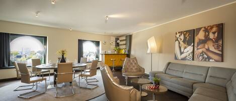 A modern living room with a dining area, a sofa, and a coffee table.