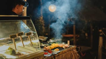 A food stall with a grill and a display case, likely at an outdoor event or market.