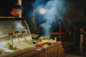 A food stall with a grill and a display case, likely at an outdoor event or market. - Munduk Moding Plantation Nature Resort (Gobleg)