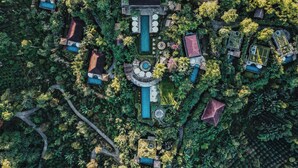 An aerial view of a resort with multiple buildings, a central pool, and lush greenery. - Munduk Moding Plantation Nature Resort (Gobleg)