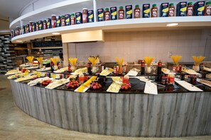 A buffet setup with various food items and condiments.