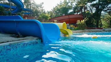 Enjoy a refreshing swim in our pool surrounded by lush trees and a fun water slide.