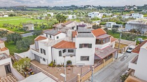 A residential area with white buildings, a paved road, and green fields in the background. - Casa Del Sole Relax Room (Castrignano del Capo)