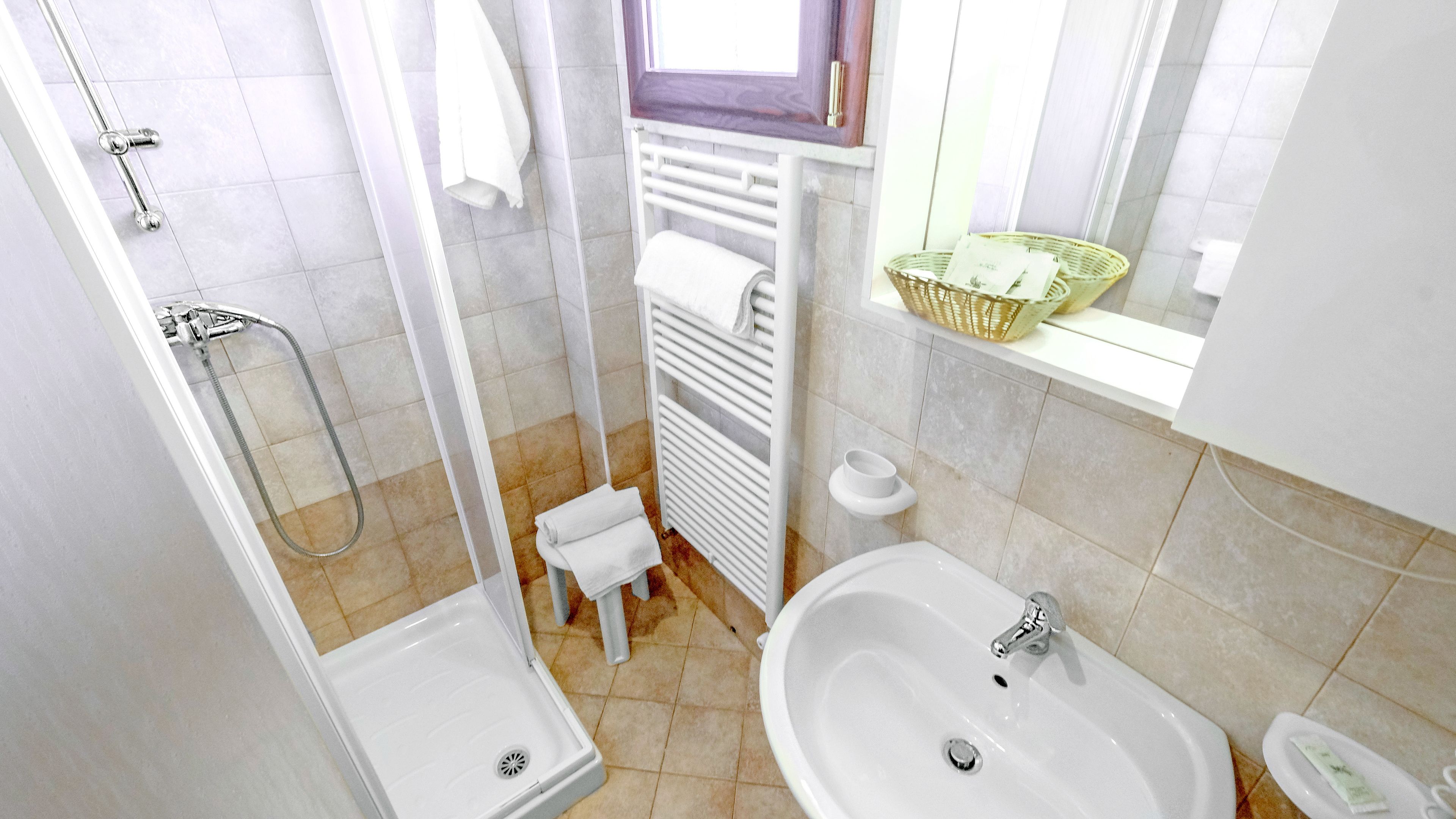 A bathroom with a shower, a sink, and a toilet.