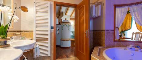 A bathroom with two sinks, a bathtub, a mirror, and a towel rack.