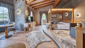 Une chambre spacieuse dotée d ’un lit à baldaquin, d’un plafond en bois et d’une grande fenêtre donnant sur l’extérieur.