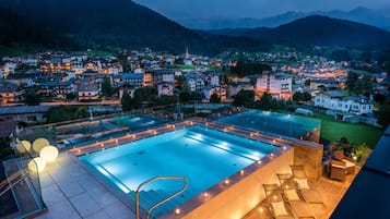 Una piscina techada, sillones reclinables de piscina