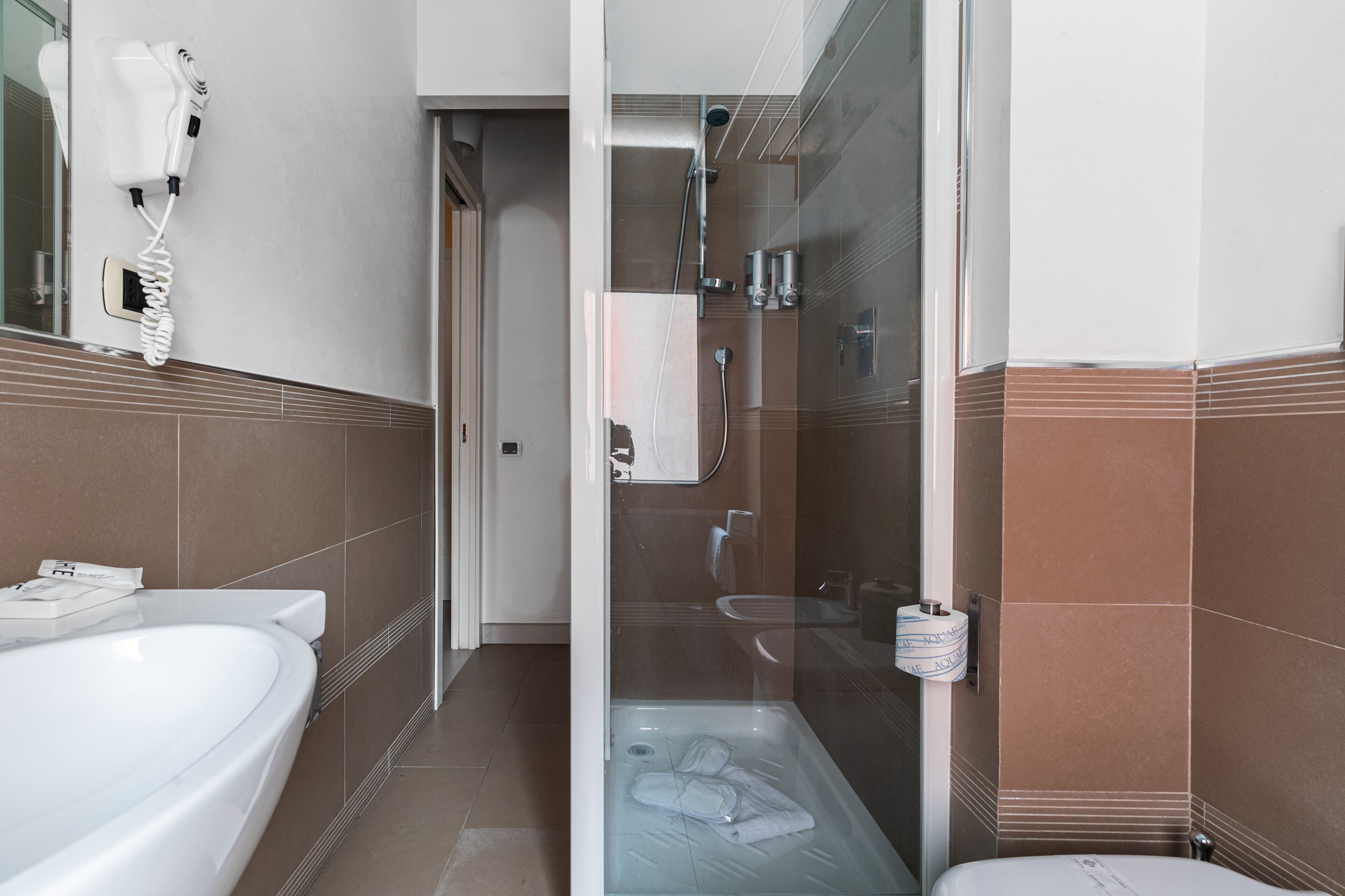 Een moderne badkamer met een badkuip, een douche met glazen wanden en een toilet.
