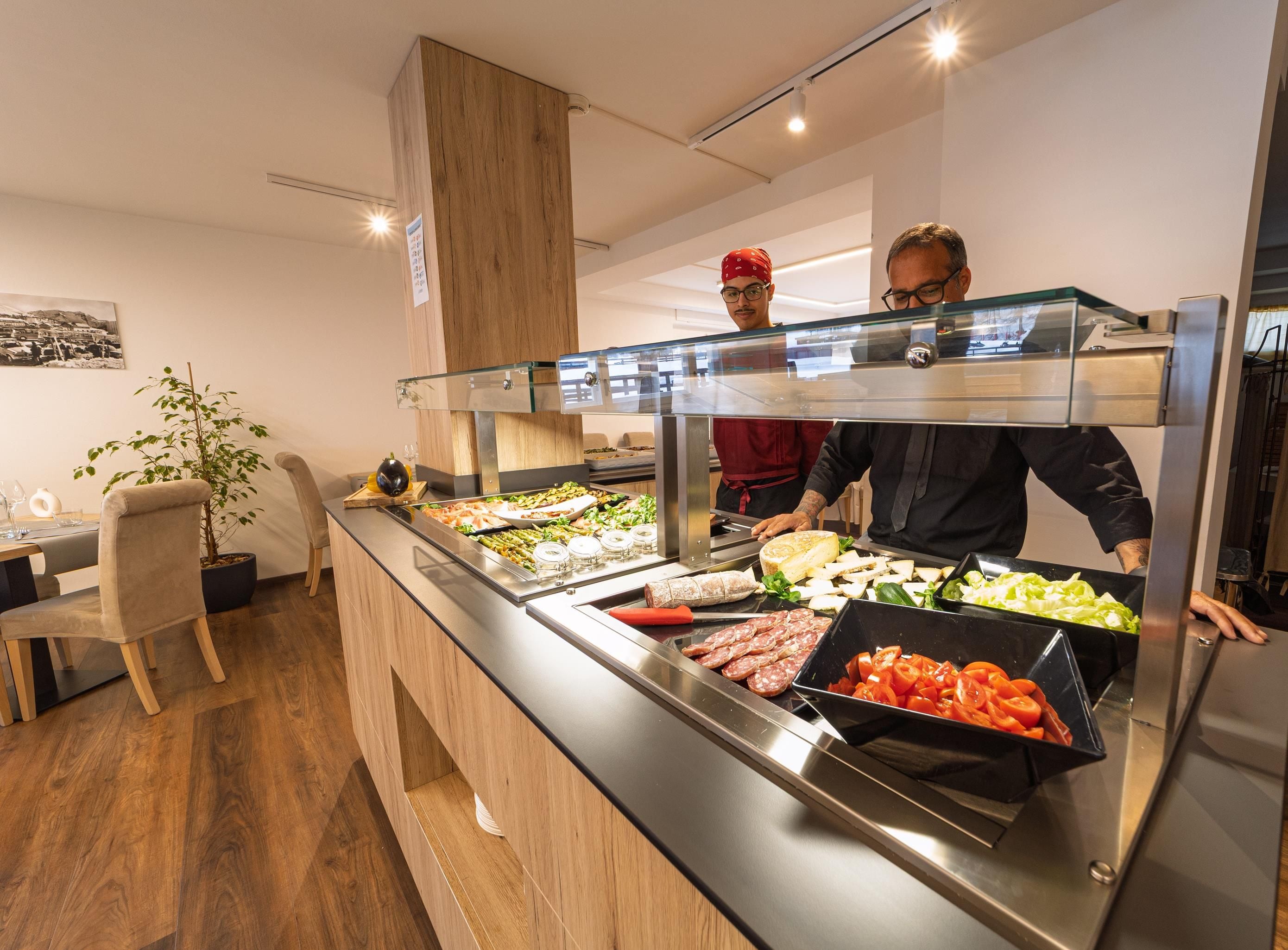 Een buffetgedeelte met diverse soorten eten, zoals vlees, kaas en groenten.