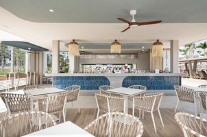 Uma área de bar com balcão, assentos e ventilador de teto.